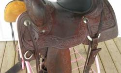 THIS BEAUTIFUL VINTON (USA) COW HORSE SADDLE HAS AN INLAID PADDED 16 INCH SEAT TASTEFUL AND UNIQUE BORDER FLORAL TOOLING EVEN HAS THE YEAR '2010' CARVED IN TO THE SADDLE IN BORDER TOOL IN SEVERAL PLACES - TREE IS A FULL QH BAR AND A LITTLE WIDER TO 'PAD